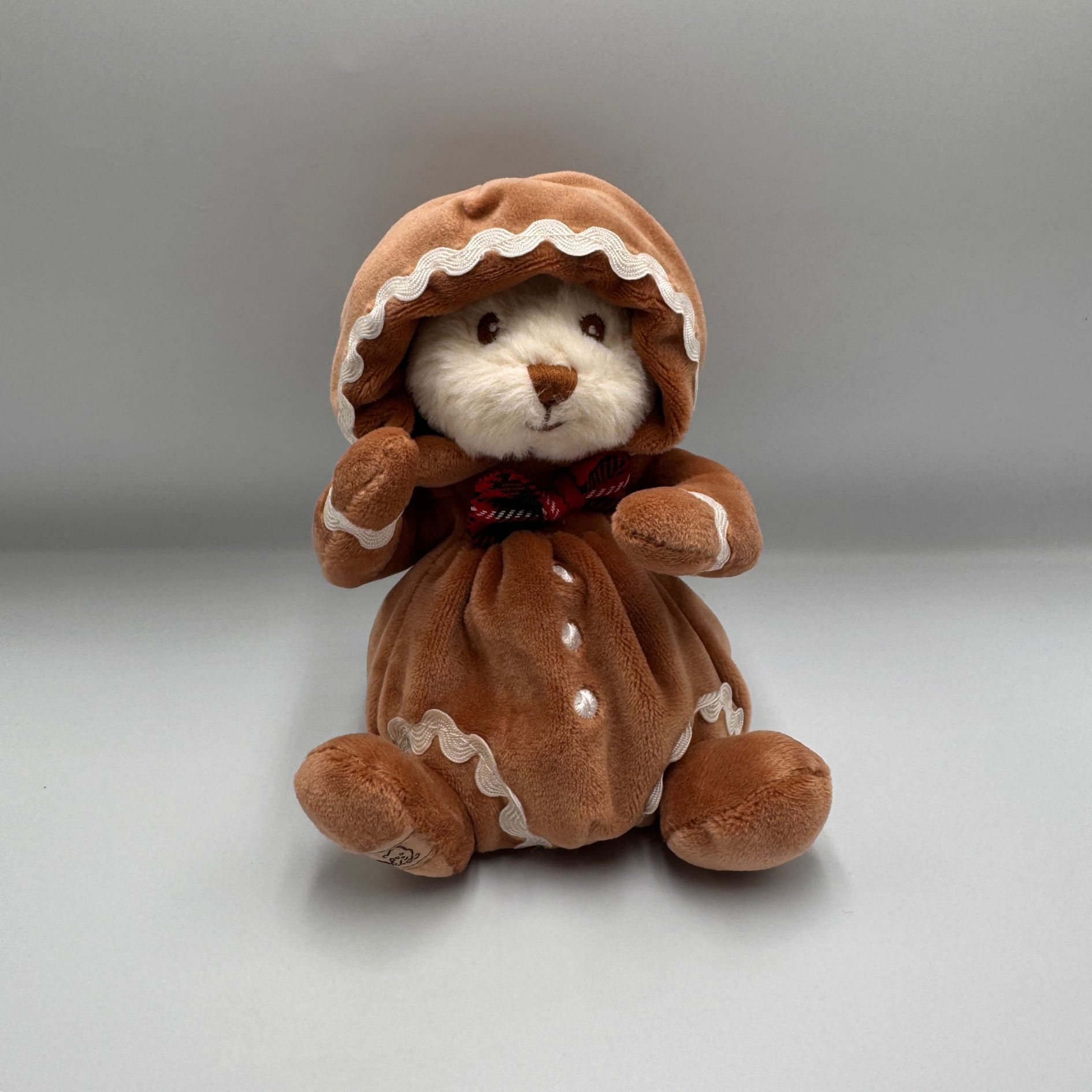 Miś Bukowski Ziggy Gingerbread 15 cm w brązowym stroju pierniczka z czerwoną muszką.